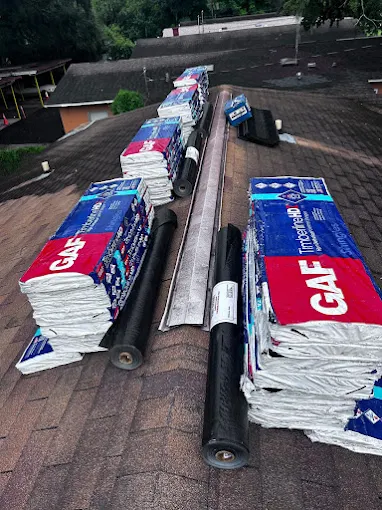 GAF Timberline HD shingle bundles and underlayment staged on a roof